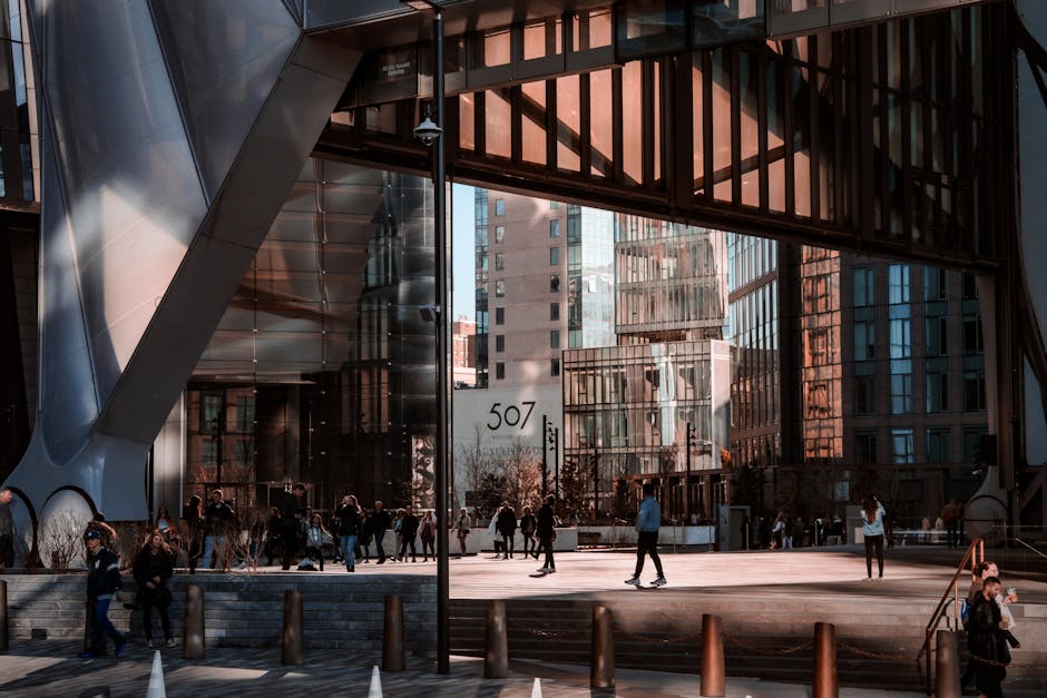 A photo of a busy city street with cars and pedestrians.  The street is lined with tall buildings.