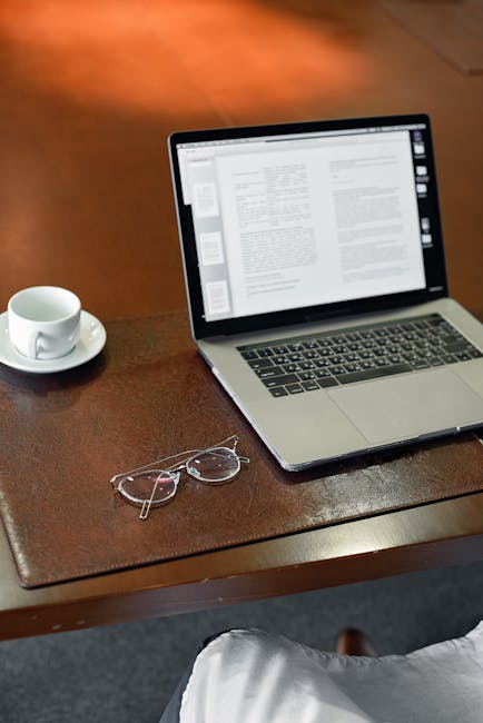 노트북 화면에 파이썬 코드가 줄지어 흐르고, 옆에는 커피잔이 놓여 있고, 화면에는 집중된 표정이 있는, 키보드를 치는 누군가의 손 클로즈업